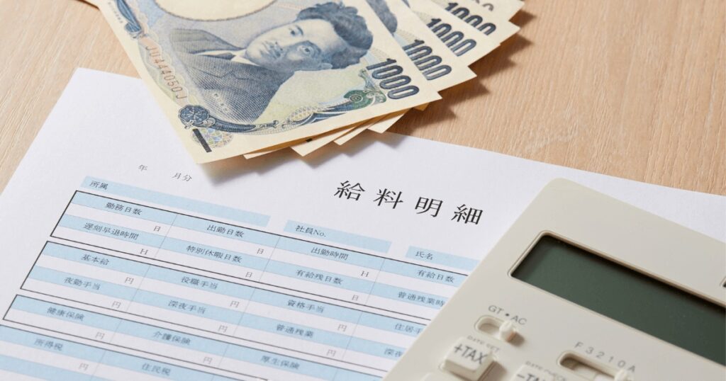 給料と現金、電卓の画像